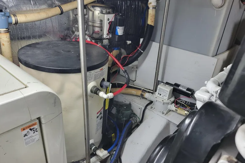 Slide: The Image of Engine room of a 2001 Carver 570 Voyager Pilothouse with mechanical components and wiring. - 139