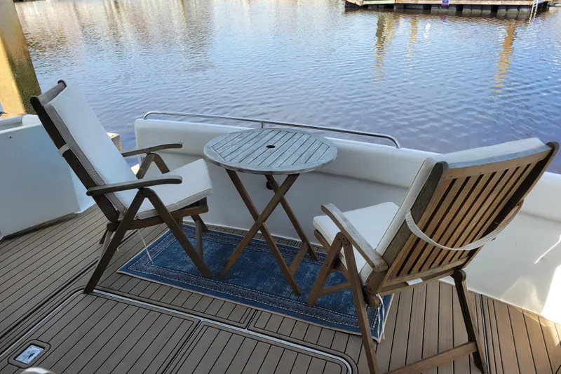 Slide: The Image of Outdoor seating on 2001 Carver 570 Voyager Pilothouse yacht, overlooking serene water. - 153