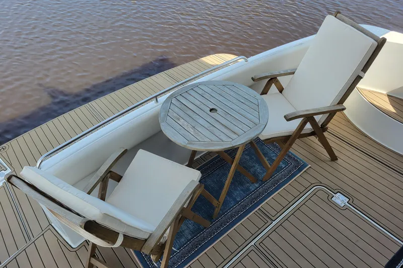 Slide: The Image of Deck seating area on 2001 Carver 570 Voyager Pilothouse with wooden chairs and table. - 155