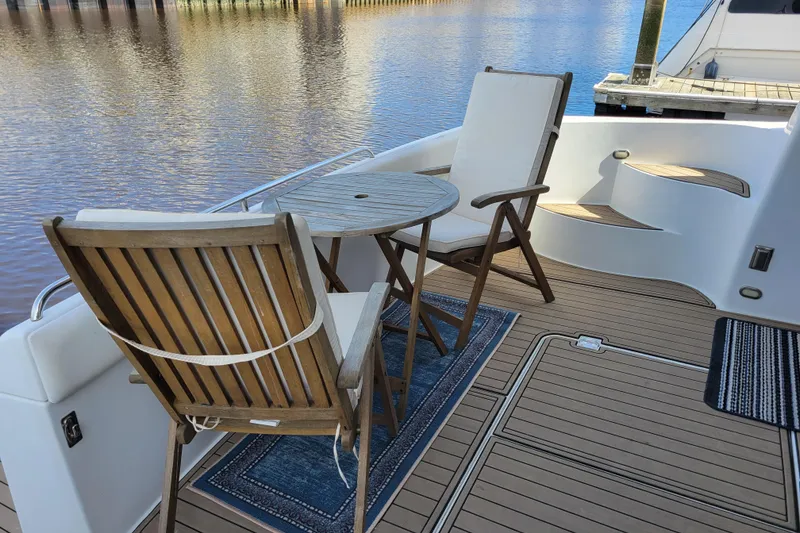 Slide: The Image of Deck seating on 2001 Carver 570 Voyager Pilothouse yacht, overlooking serene water. - 156