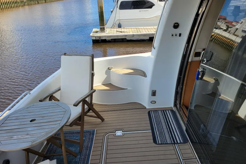 Slide: The Image of Deck of 2001 Carver 570 Voyager Pilothouse with chair and table by the water. - 157