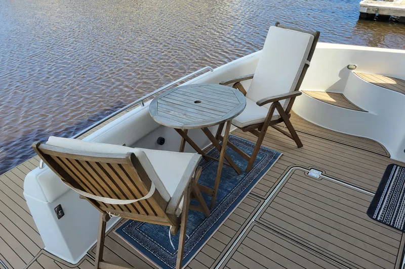 Slide: The Image of Deck of 2001 Carver 570 Voyager Pilothouse with chairs and table by the water. - 158
