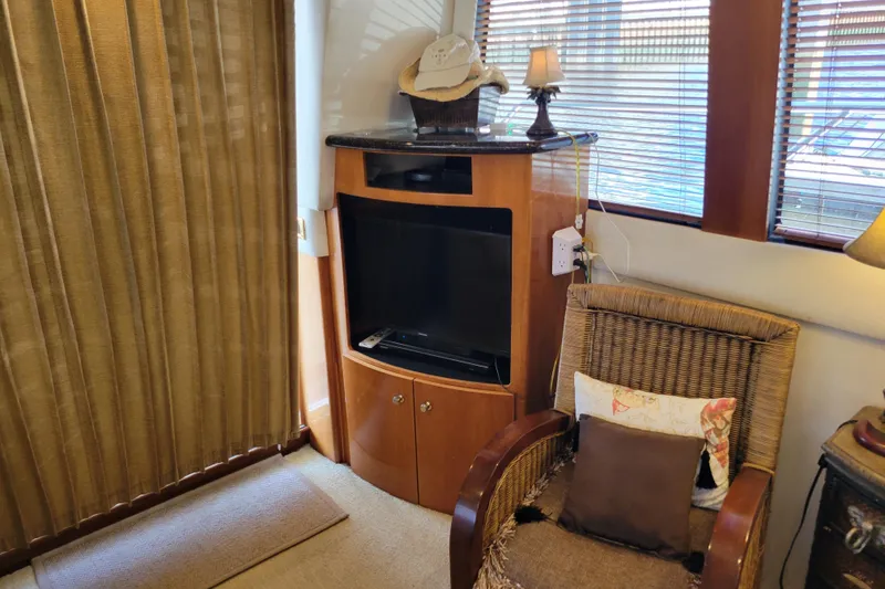 Slide: The Image of Interior of 2001 Carver 570 Voyager Pilothouse with TV, wicker chair, and decor. - 16