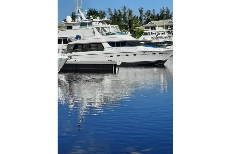 Slide: The Image of 2001 Carver 570 Voyager Pilothouse yacht docked in a serene marina setting. - 161