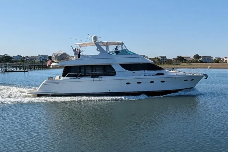 Slide: The Image of 2001 Carver 570 Voyager Pilothouse yacht cruising on calm waters near shoreline. - 164