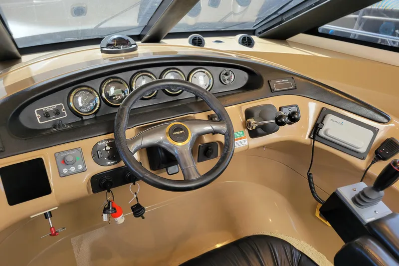 Slide: The Image of 2001 Carver 570 Voyager Pilothouse helm with gauges, steering wheel, and navigation controls. - 33