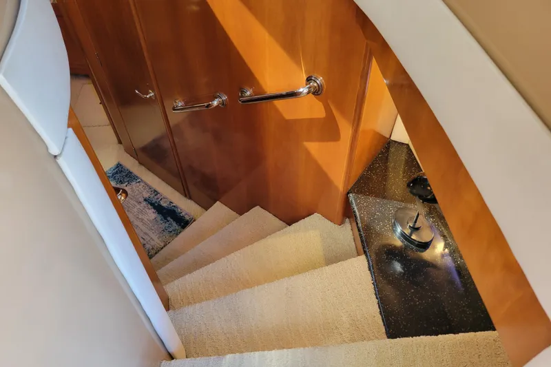 Slide: The Image of Staircase inside 2001 Carver 570 Voyager Pilothouse with wooden paneling and carpeted steps. - 47