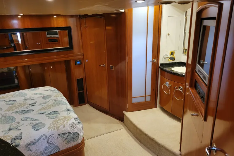 Slide: The Image of Luxurious interior of 2001 Carver 570 Voyager Pilothouse yacht with wood finishes and cozy bedding. - 62