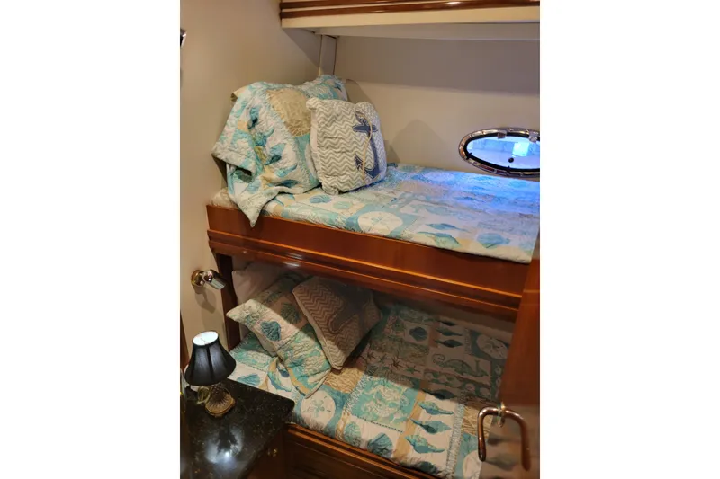 Slide: The Image of Bunk beds in 2001 Carver 570 Voyager Pilothouse with nautical-themed bedding and porthole window. - 69