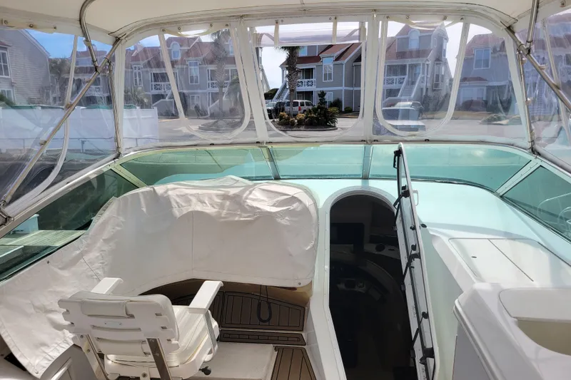 Slide: The Image of 2001 Carver 570 Voyager Pilothouse interior with helm and seating area. - 80