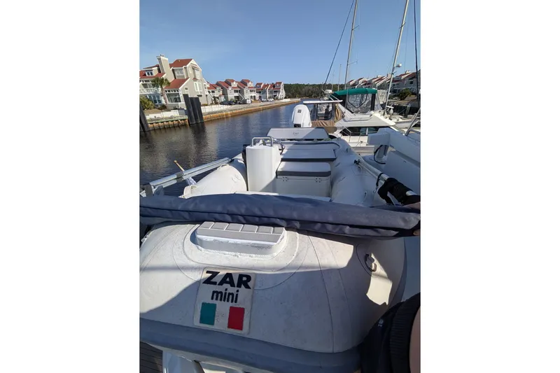 Slide: The Image of 2001 Carver 570 Voyager Pilothouse with Zar Mini inflatable boat docked in a marina. - 91