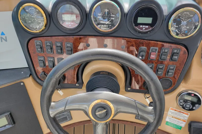 Slide: The Image of Control panel of a 2001 Carver 570 Voyager Pilothouse with steering wheel and gauges. - 94