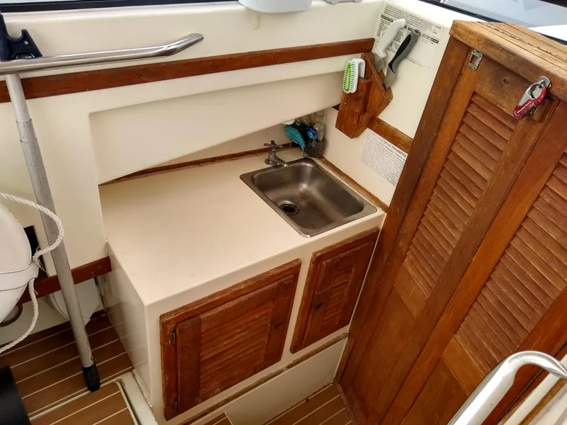 Slide: The Image of 1988 Albemarle 27 Express Fisherman interior with sink and wooden cabinets. - 19