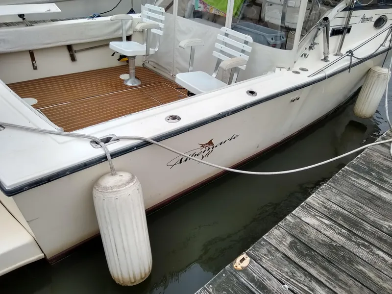 Slide: The Image of 1988 Albemarle 27 Express Fisherman boat docked with white fenders and wooden deck. - 35