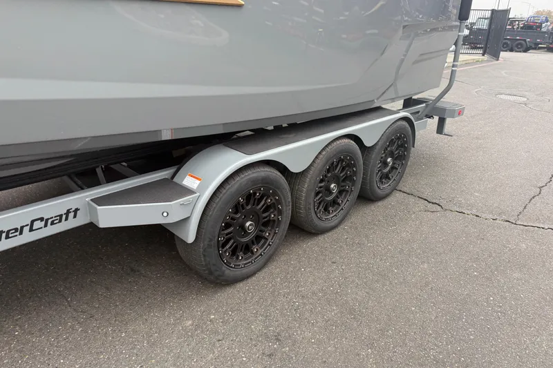 Slide: The Image of 2026 MasterCraft X24 boat trailer with triple axle and black wheels. - 10