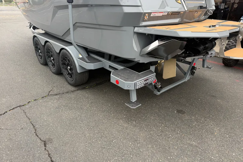 Slide: The Image of 2026 MasterCraft X24 boat on a trailer, showcasing rear design and triple-axle wheels. - 11