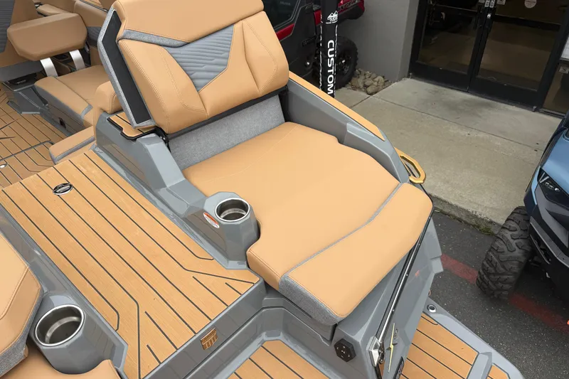 Slide: The Image of 2026 MasterCraft X24 boat interior with tan seating and cup holders. - 16