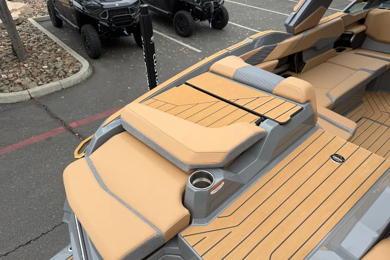 Slide: The Image of 2026 MasterCraft X24 boat interior with tan seating and wood-style flooring. - 17