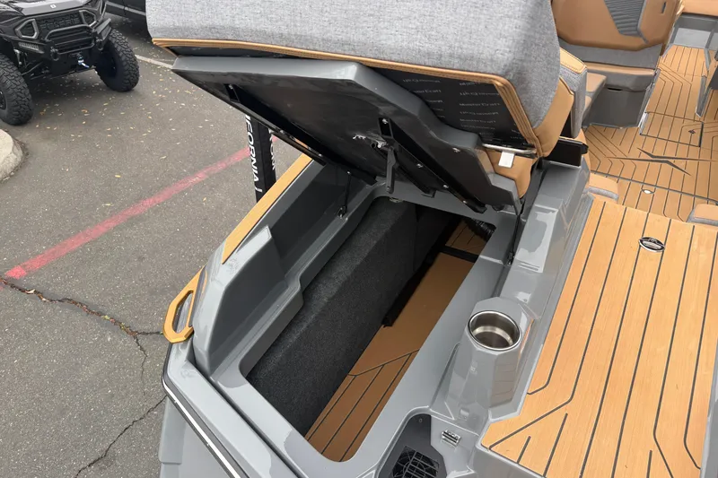 Slide: The Image of 2026 MasterCraft X24 boat with open storage compartment and cushioned seating. - 22