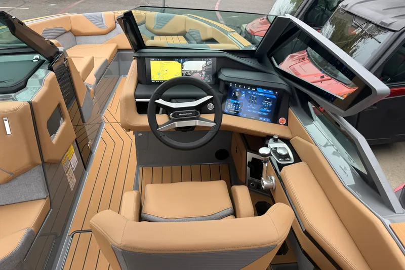 Slide: The Image of 2026 MasterCraft X24 boat interior with advanced dashboard and tan seating. - 28