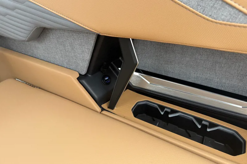 Slide: The Image of Interior detail of 2026 MasterCraft X24 boat, featuring tan and gray upholstery with cup holder. - 40