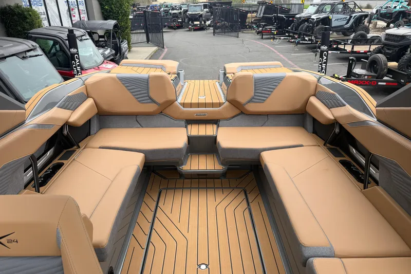 Slide: The Image of 2026 MasterCraft X24 boat interior with tan and gray seating, showcasing spacious design. - 43