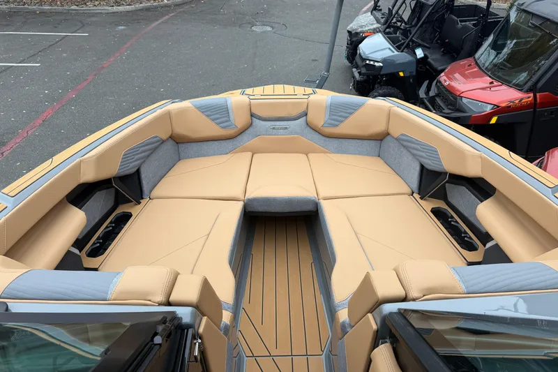Slide: The Image of 2026 MasterCraft X24 boat interior with tan and gray seating, showcasing spacious design. - 58
