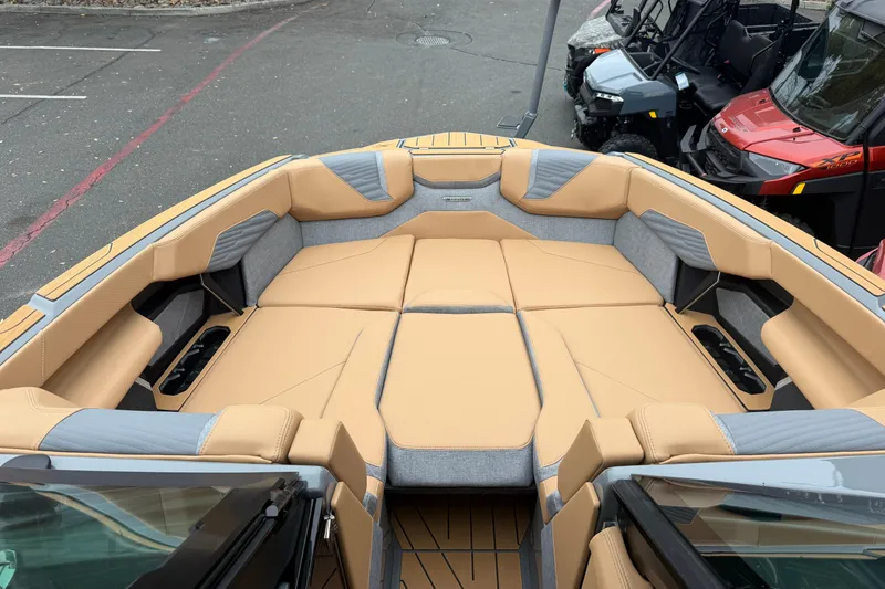 Slide: The Image of 2026 MasterCraft X24 boat interior with tan and gray seating, showcasing spacious design. - 59
