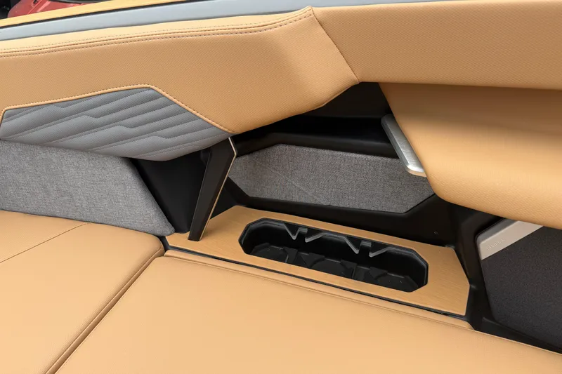 Slide: The Image of 2026 MasterCraft X24 interior detail with tan and gray upholstery, featuring cup holders. - 69