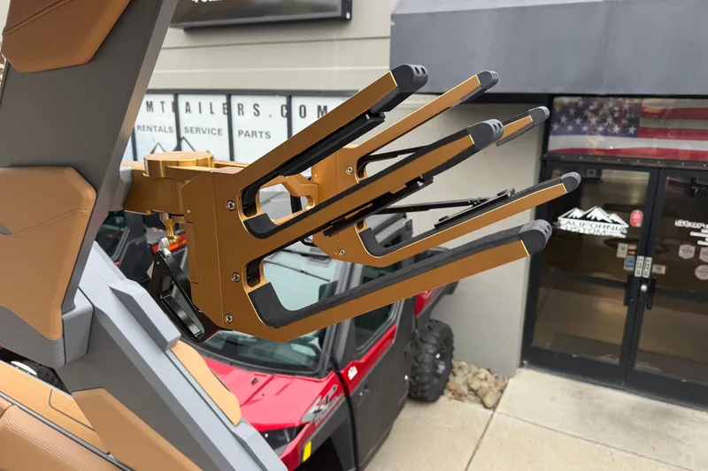 Slide: The Image of 2026 MasterCraft X24 wakeboard rack with gold accents, mounted on a boat. - 74