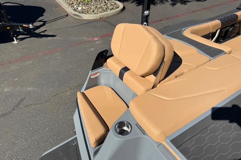 Slide: The Image of 2026 MasterCraft XT24 boat with tan leather seating and cup holder on deck. - 15