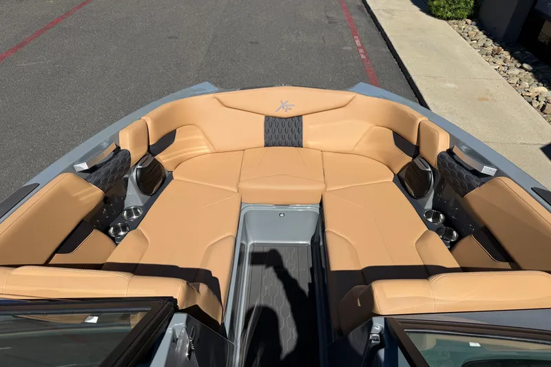 Slide: The Image of 2026 MasterCraft XT24 boat interior with tan seating and cup holders. - 28