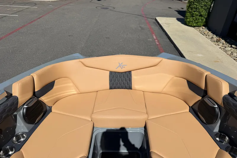 Slide: The Image of 2026 MasterCraft XT24 boat interior with tan seating and cup holders. - 30