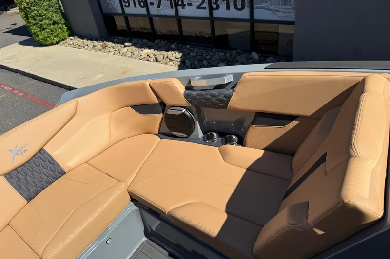 Slide: The Image of 2026 MasterCraft XT24 boat interior with tan leather seating and cup holders. - 31