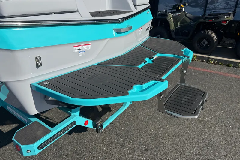 Slide: The Image of 2026 MasterCraft XT23 boat with teal and black swim platform and step ladder. - 11