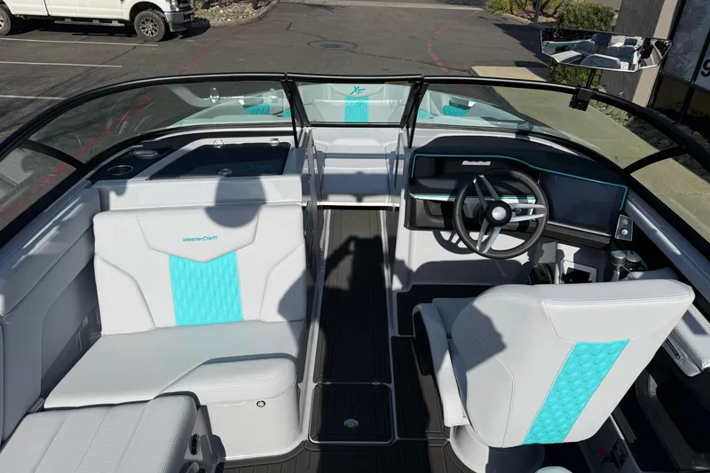 Slide: The Image of 2026 MasterCraft XT23 boat interior with modern dashboard and turquoise-accented seating. - 23