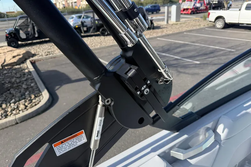 Slide: The Image of 2026 MasterCraft XT23 boat tower hinge detail in a parking lot setting. - 28
