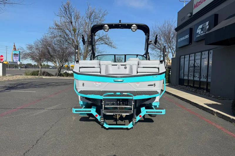 Slide: The Image of 2026 MasterCraft XT23 boat, turquoise and gray, parked outside dealership. - 3