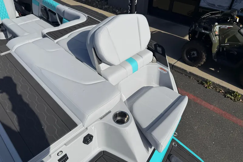 Slide: The Image of 2026 MasterCraft XT23 boat interior with white and teal seating, cup holder, and sleek design. - 33