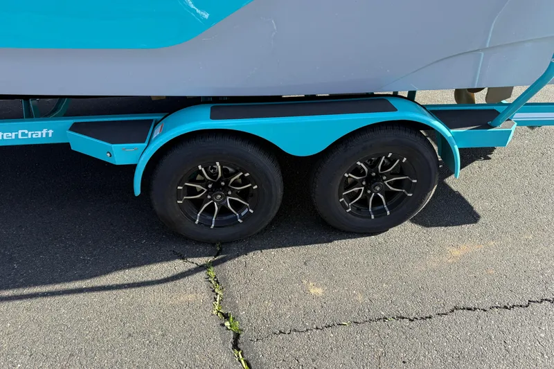 Slide: The Image of 2026 MasterCraft XT23 trailer with black alloy wheels on asphalt. - 9