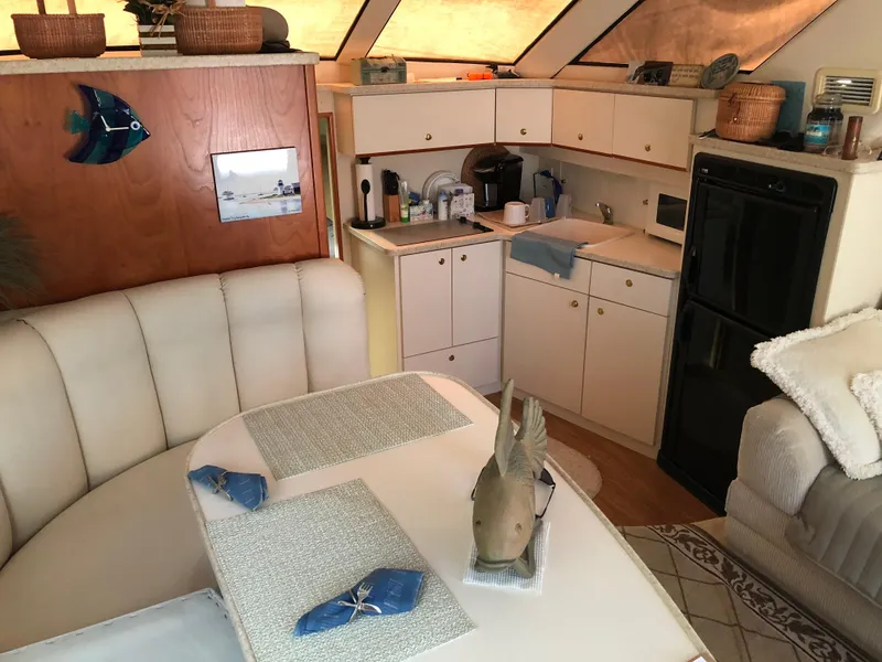 Slide: The Image of Interior of a 1999 Silverton 351 Sedan yacht, featuring kitchen and dining area. - 10