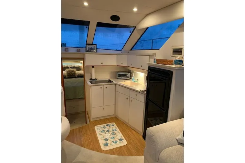 Slide: The Image of Interior of a 1999 Silverton 351 Sedan yacht with kitchenette and cozy decor. - 12