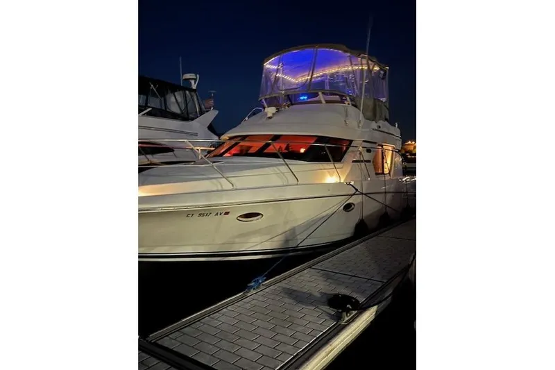 Slide: The Image of 1999 Silverton 351 Sedan yacht docked at night with illuminated upper deck. - 2