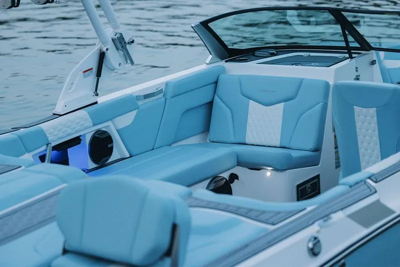 Slide: The Image of Manufacturer Provided Image: 2026 MasterCraft XT22 boat interior with blue and white seating, on calm water. - 5