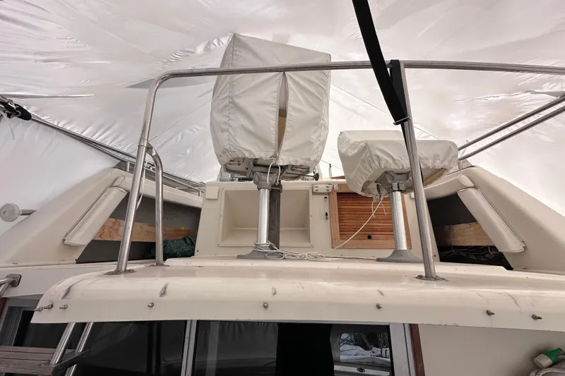 Slide: The Image of 1988 Silverton 37 Convertible boat interior with covered seats and railing. - 11