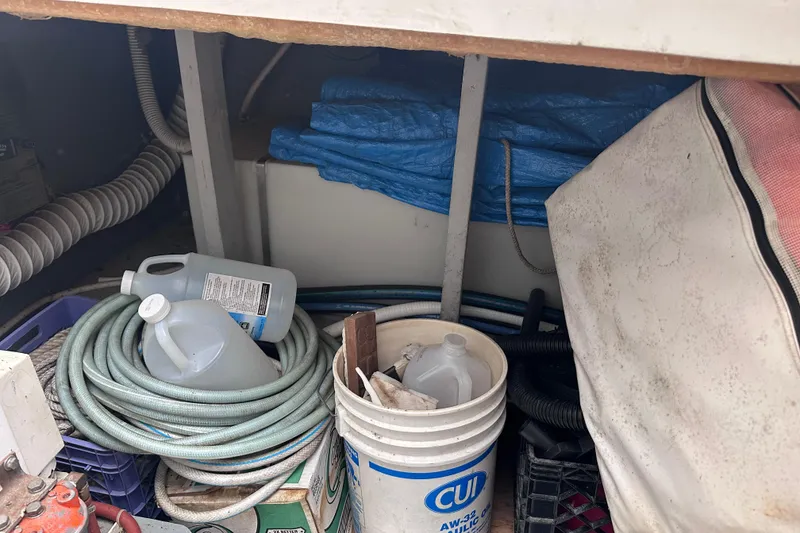 Slide: The Image of Storage area on a 1988 Silverton 37 Convertible boat with hoses and containers. - 17