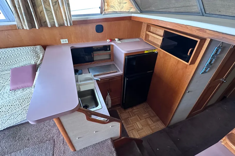 Slide: The Image of 1988 Silverton 37 Convertible boat interior with kitchenette, sink, and compact fridge. - 23