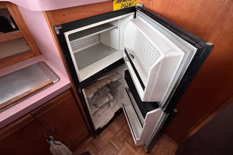 Slide: The Image of Open refrigerator inside a 1988 Silverton 37 Convertible boat kitchen area. - 25