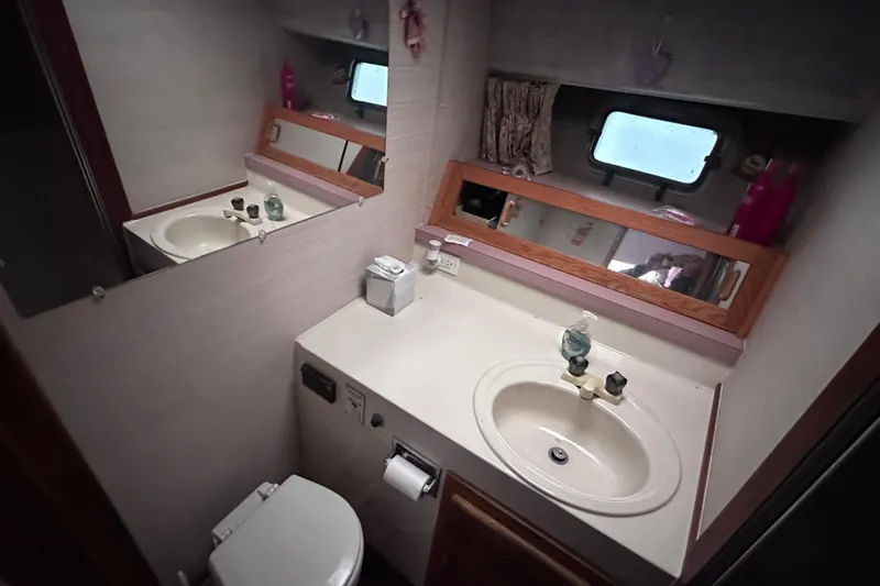 Slide: The Image of 1988 Silverton 37 Convertible yacht bathroom with sink, mirror, and window. - 27