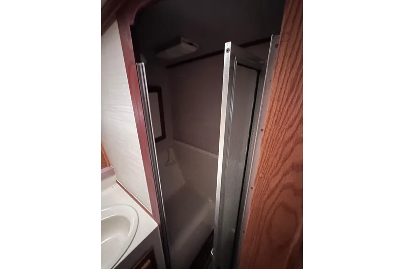 Slide: The Image of 1988 Silverton 37 Convertible bathroom with shower and sink, featuring wood accents. - 28